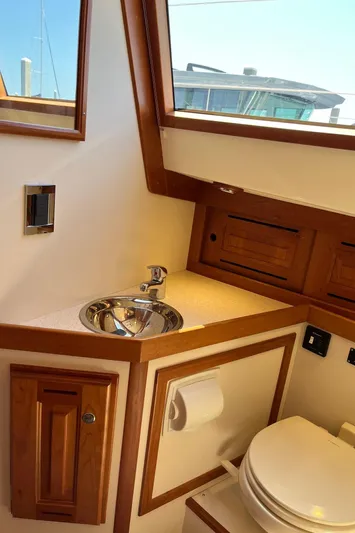 Sapphire Yacht Photos Pics 2014 Tartan 4700 yacht bathroom with wooden cabinetry and stainless steel sink.