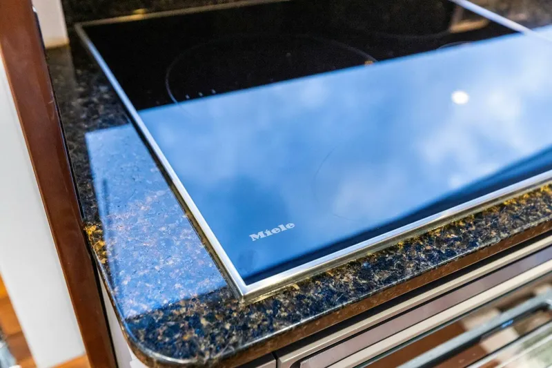 Amarula Sun Yacht Photos Pics Modern Miele cooktop on granite countertop in 2024 Princess X80 yacht kitchen.