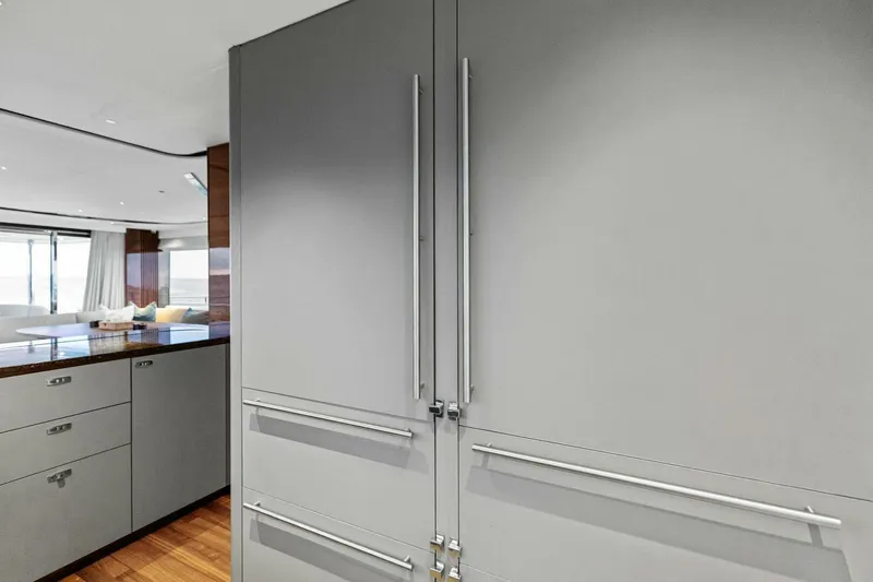 Amarula Sun Yacht Photos Pics Modern kitchen interior on 2024 Princess X80 yacht, featuring sleek cabinetry and wood flooring.