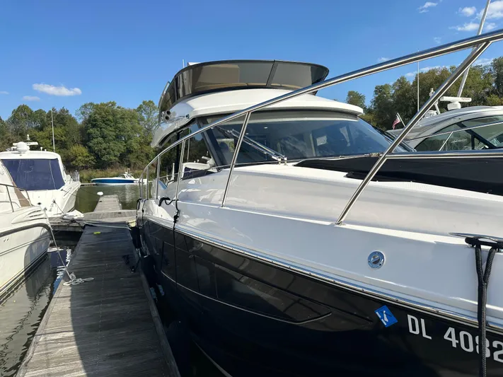Vinovoyager Yacht Photos Pics 2021 Regal 42 FXO yacht docked at marina, clear sky, lush trees in background.