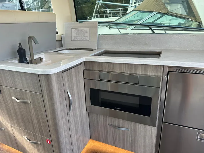 Vinovoyager Yacht Photos Pics Modern kitchen area in 2021 Regal 42 FXO yacht with sleek cabinetry and appliances.