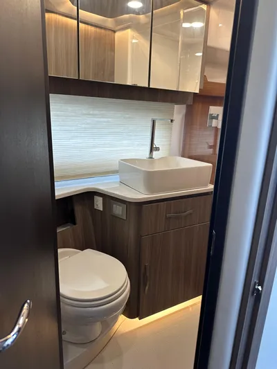 Vinovoyager Yacht Photos Pics Luxurious bathroom in 2021 Regal 42 FXO yacht with modern fixtures and wood cabinetry.