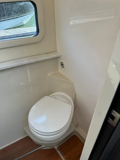 Vinovoyager Yacht Photos Pics 2021 Regal 42 FXO boat bathroom with compact toilet and window.