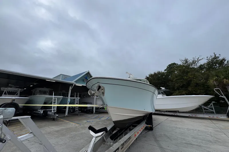  Yacht Photos Pics 2024 Grady-White Canyon 386 boat on trailer at dealership, cloudy sky background.