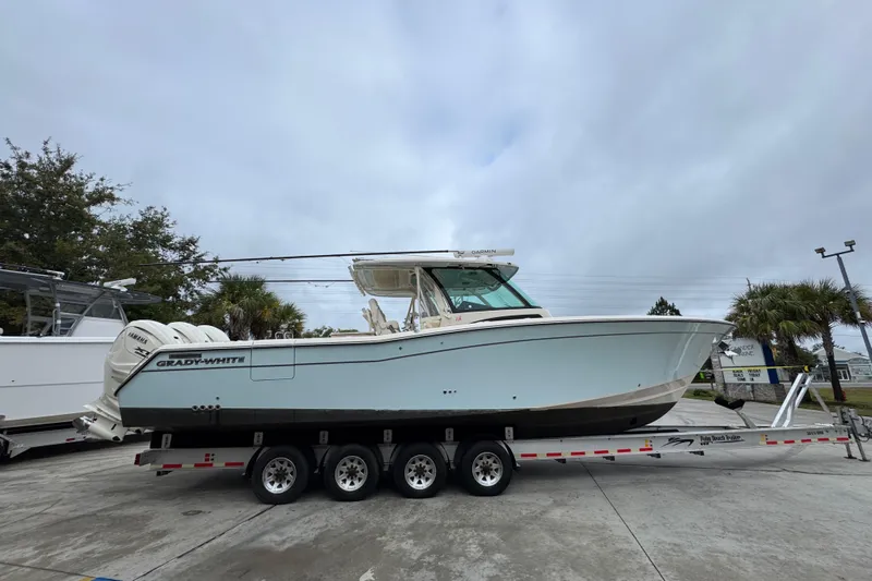  Yacht Photos Pics 2024 Grady-White Canyon 386 boat on trailer, parked outdoors under cloudy sky.