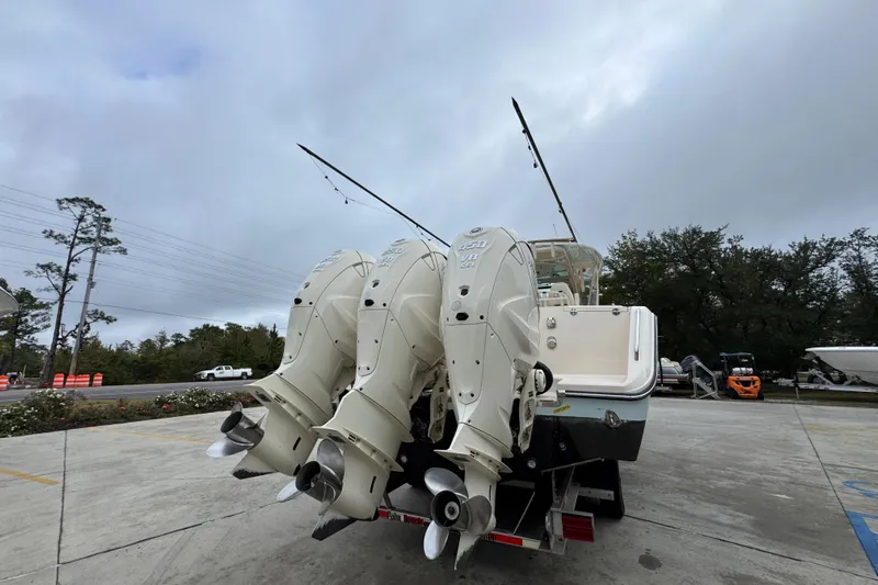  Yacht Photos Pics 2024 Grady-White Canyon 386 boat with triple outboard engines, parked outdoors.