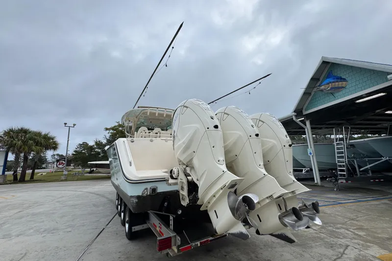  Yacht Photos Pics 2024 Grady-White Canyon 386 boat with triple outboard engines in a marina setting.