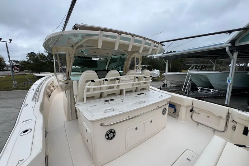 Yacht Photos Pics 2024 Grady-White Canyon 386 boat interior with seating and storage, docked under cloudy skies.