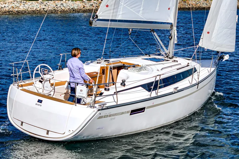 New Sailboat Yacht Photos Pics 2024 Bavaria Cruiser 34 sailing on water with person at the helm.