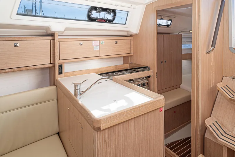 New Sailboat Yacht Photos Pics Interior of 2024 Bavaria Cruiser 34 yacht with modern kitchen and wooden cabinetry.