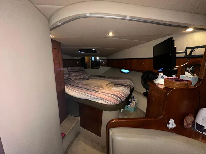  Yacht Photos Pics 2005 Cruisers Yachts 340 Express cabin interior with bed, TV, and wooden cabinetry.