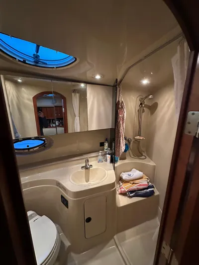  Yacht Photos Pics 2005 Cruisers Yachts 340 Express bathroom with sink, shower, and porthole window.