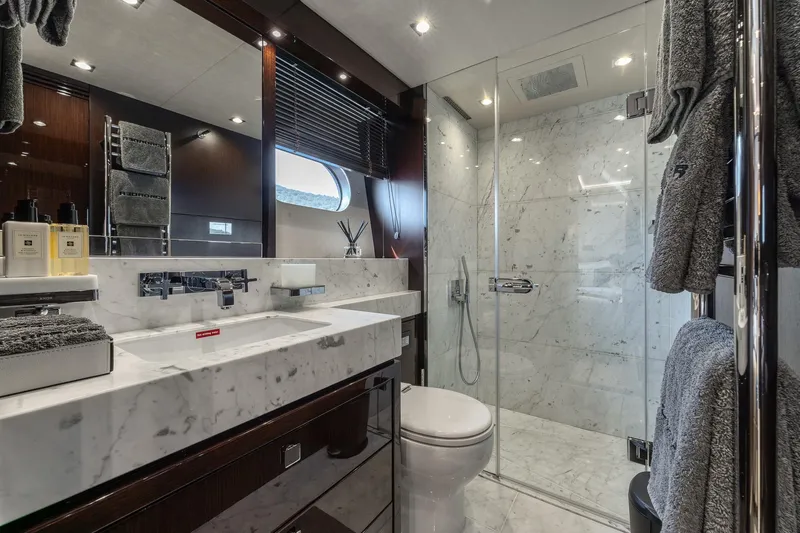 Noroader Yacht Photos Pics Luxurious marble bathroom in 2020 Sunseeker 116 yacht with modern fixtures and glass shower.