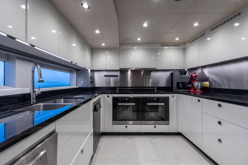 Noroader Yacht Photos Pics Luxurious modern kitchen on a 2020 Sunseeker 116 yacht, featuring sleek cabinetry and appliances.