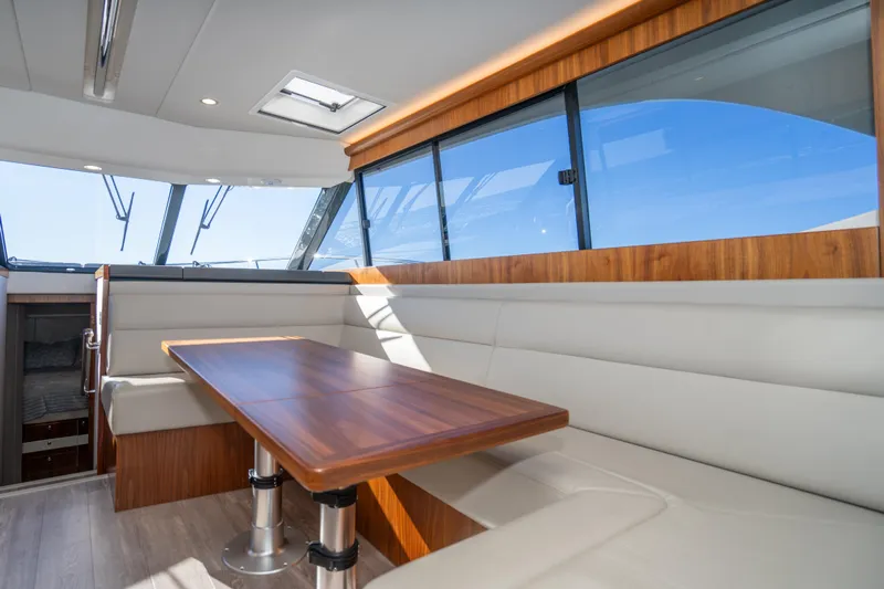  Yacht Photos Pics Luxurious interior of 2022 Riviera 445 SUV yacht with elegant wood and leather seating.