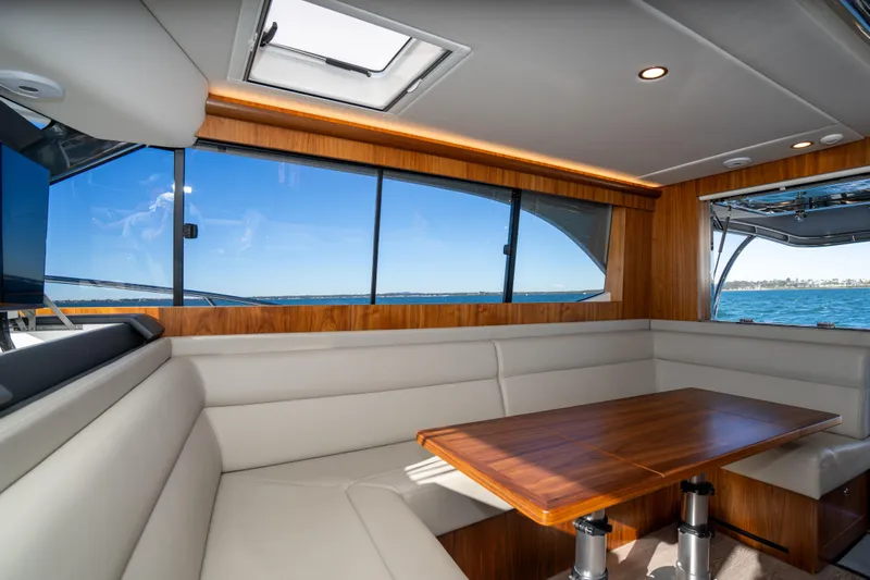  Yacht Photos Pics Luxurious interior of 2022 Riviera 445 SUV yacht with elegant wood and leather seating.