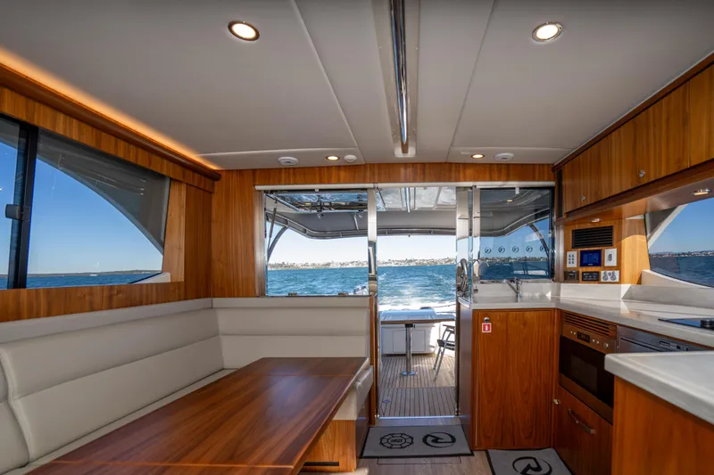  Yacht Photos Pics Luxurious interior of 2022 Riviera 445 SUV yacht with ocean view through open doors.