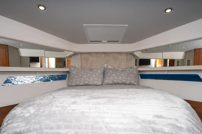  Yacht Photos Pics Luxurious bedroom interior of 2022 Riviera 445 SUV yacht with elegant bedding.