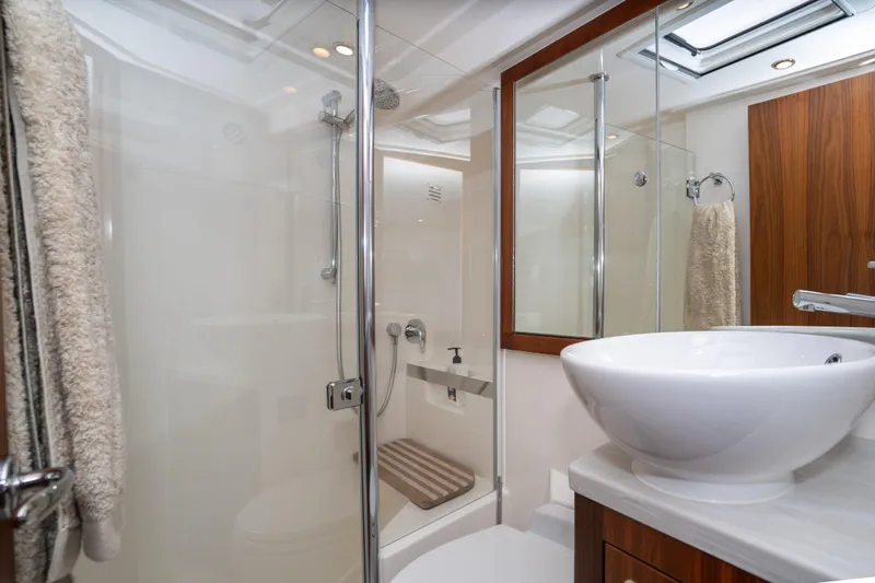  Yacht Photos Pics Luxurious bathroom in 2022 Riviera 445 SUV yacht with modern fixtures and elegant design.