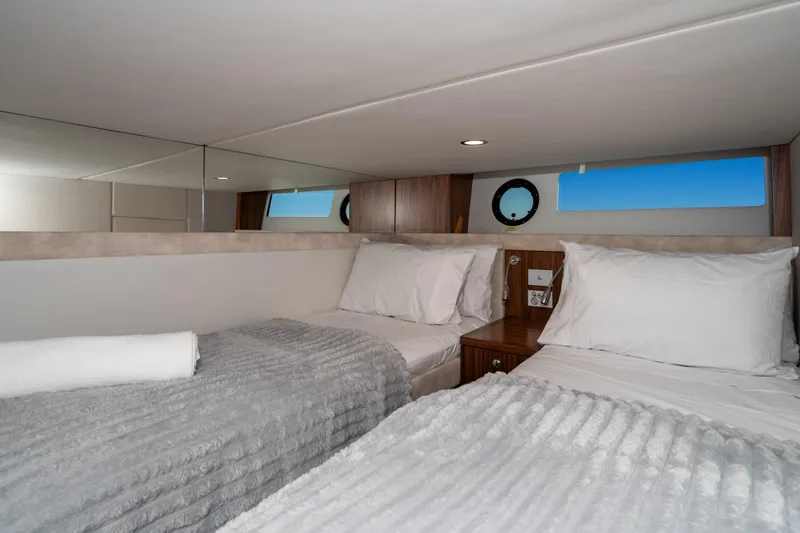  Yacht Photos Pics Luxurious 2022 Riviera 445 SUV cabin with twin beds and elegant decor.