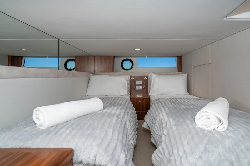  Yacht Photos Pics Luxurious twin cabin interior of 2022 Riviera 445 SUV yacht with plush bedding.