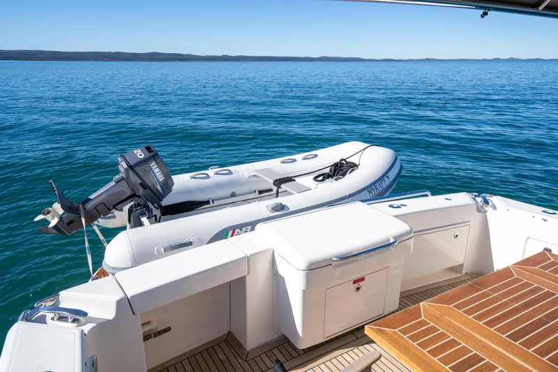  Yacht Photos Pics 2022 Riviera 445 SUV yacht with inflatable boat on calm blue water.