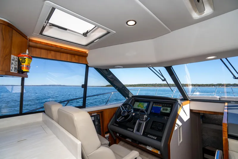  Yacht Photos Pics 2022 Riviera 445 SUV interior with modern helm, navigation screens, and ocean view.