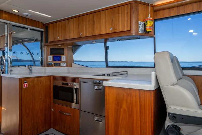  Yacht Photos Pics Luxurious interior of 2022 Riviera 445 SUV yacht with modern kitchen and ocean view.