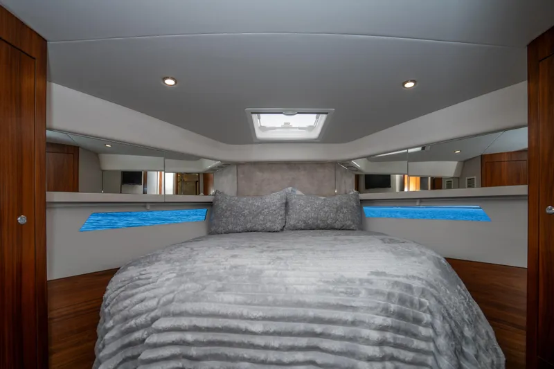  Yacht Photos Pics Luxurious bedroom interior of 2022 Riviera 445 SUV yacht with elegant bedding and wood accents.