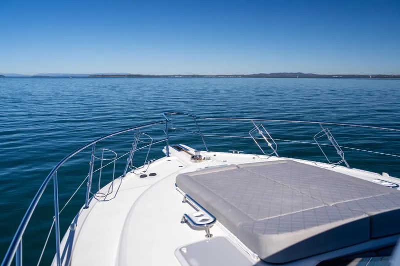  Yacht Photos Pics 2022 Riviera 445 SUV yacht on calm blue ocean under clear sky.