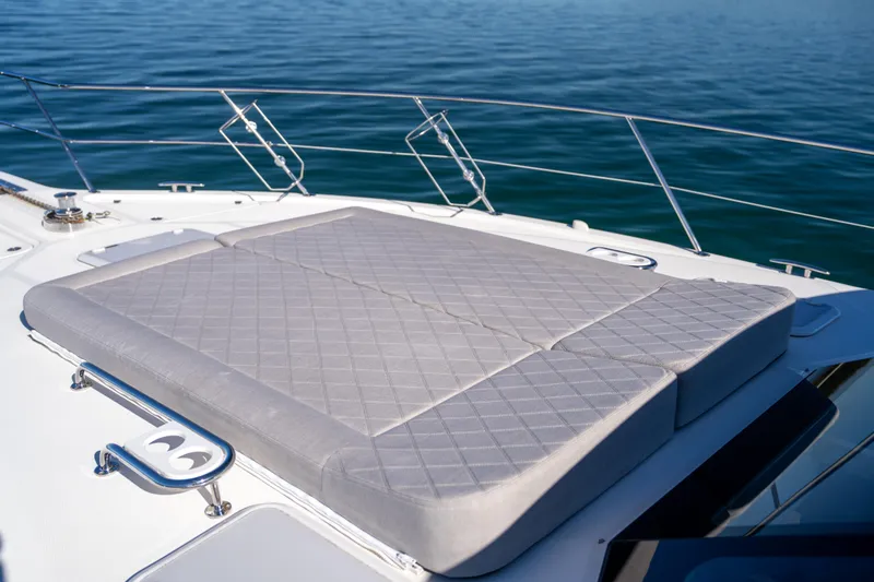  Yacht Photos Pics Sunpad on 2022 Riviera 445 SUV yacht, overlooking calm blue waters.