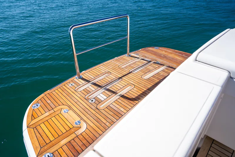  Yacht Photos Pics 2022 Riviera 445 SUV swim platform with teak decking on calm blue water.