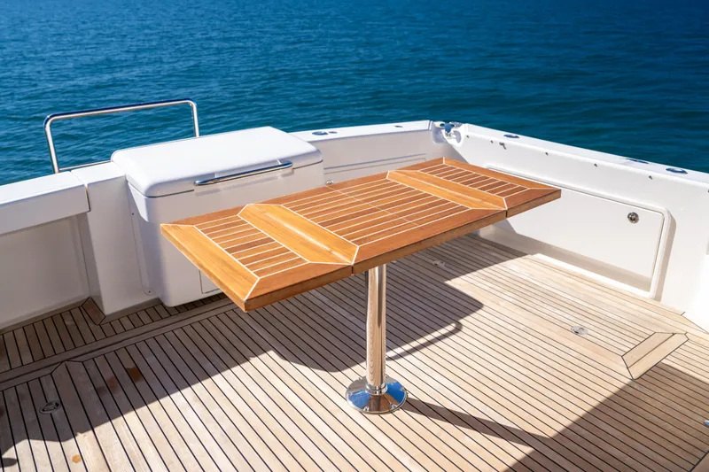  Yacht Photos Pics 2022 Riviera 445 SUV deck with wooden table and ocean view.