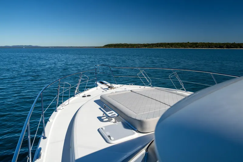  Yacht Photos Pics 2022 Riviera 445 SUV yacht cruising on serene blue waters under clear skies.