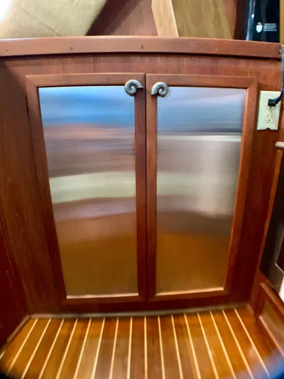 Paradise Falls Yacht Photos Pics Wooden cabinet with metal doors on a 1988 Harbor Master 520 Coastal.