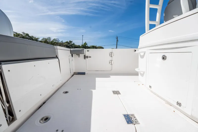  Yacht Photos Pics 2021 Everglades 335 Center Console boat deck with storage compartments under clear blue sky.