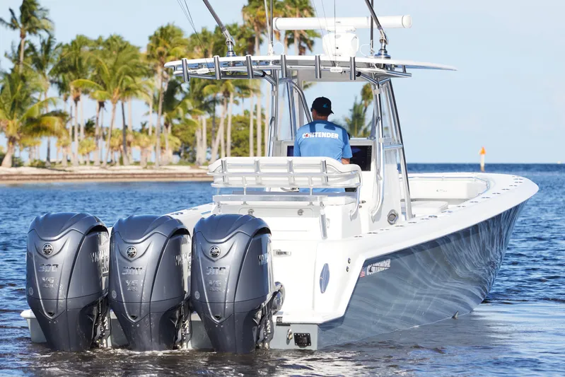  Yacht Photos Pics 2022 Contender 35 ST boat with triple Yamaha engines on water, palm trees in background.