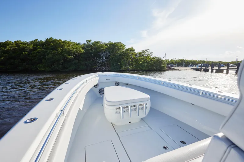  Yacht Photos Pics 2022 Contender 35 ST boat on calm water near lush green shoreline.