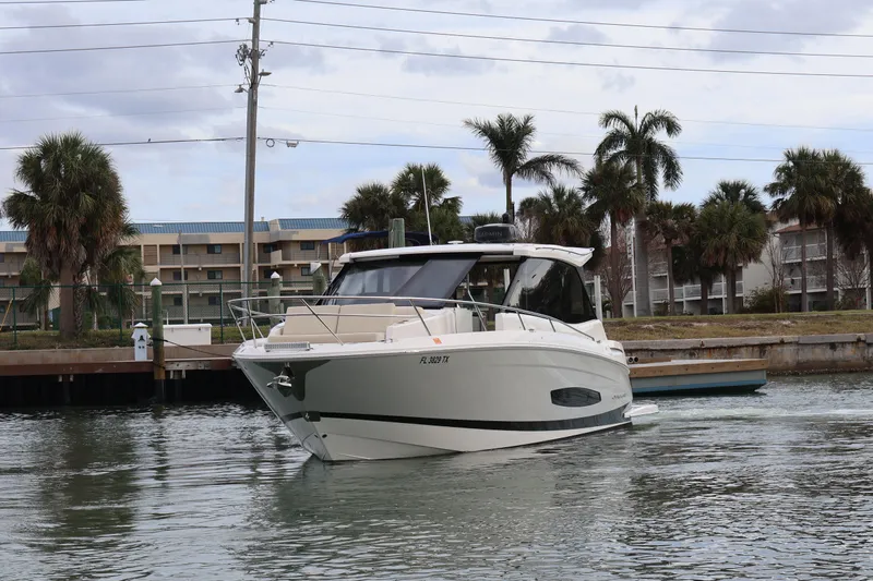  Yacht Photos Pics 2022 Regal 36 XO boat on water with palm trees and buildings in background.