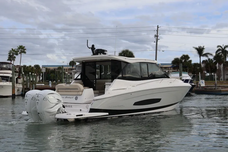  Yacht Photos Pics 2022 Regal 36 XO boat cruising in a marina with twin Yamaha engines.