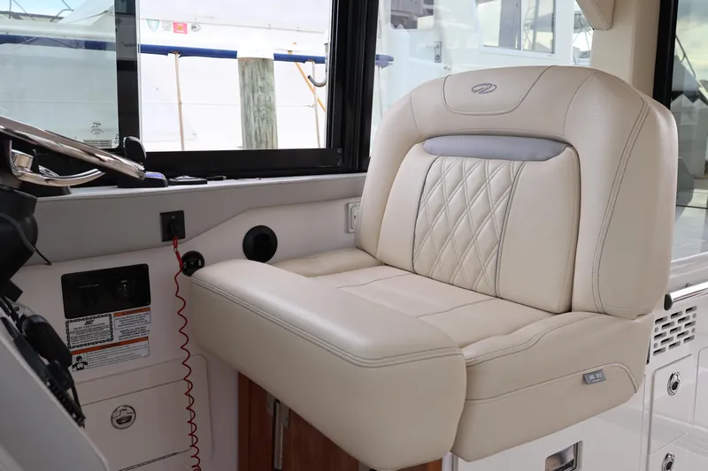  Yacht Photos Pics Luxurious helm seat in 2022 Regal 36 XO boat, featuring elegant beige upholstery.