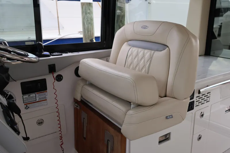  Yacht Photos Pics Luxurious helm seat in 2022 Regal 36 XO boat, featuring elegant beige upholstery.