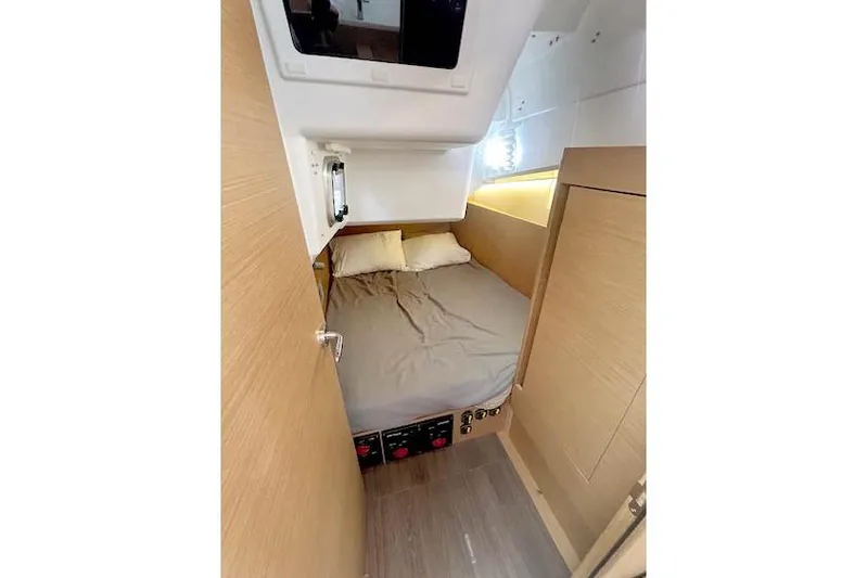 Dream Weaver Yacht Photos Pics Cozy cabin interior of 2022 Jeanneau Sun Odyssey 410 sailboat with bed and wooden finish.