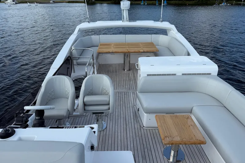  Yacht Photos Pics 2024 Sunseeker Manhattan 55 yacht deck with seating and tables on the water.