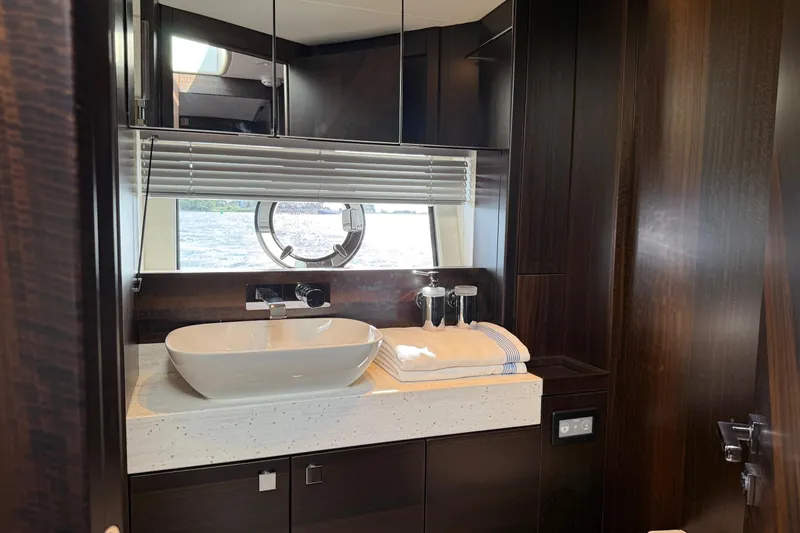  Yacht Photos Pics Luxurious bathroom interior of 2024 Sunseeker Manhattan 55 yacht with modern sink and window view.