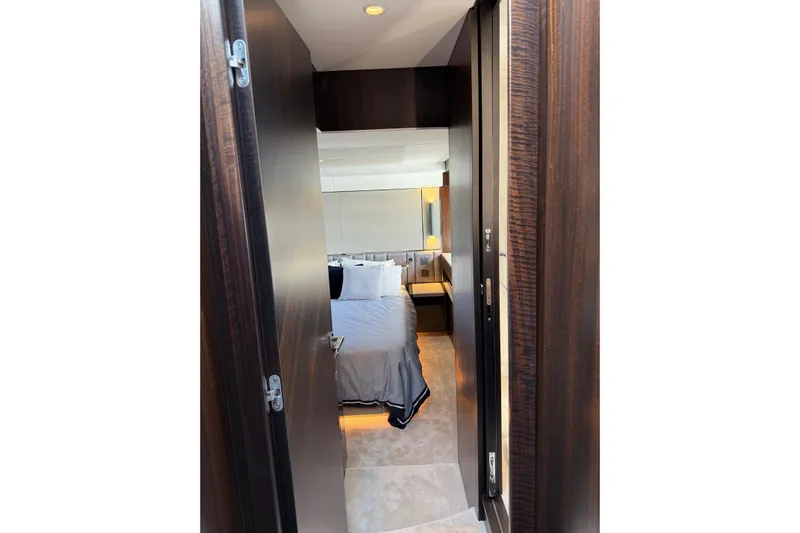  Yacht Photos Pics Luxurious bedroom interior of 2024 Sunseeker Manhattan 55 yacht, featuring elegant wood finishes.