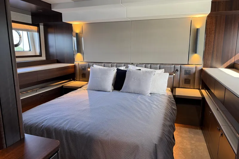  Yacht Photos Pics Luxurious bedroom interior of 2024 Sunseeker Manhattan 55 yacht, featuring elegant wood finishes.