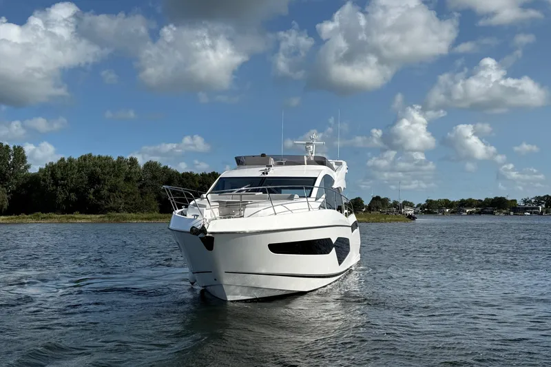  Yacht Photos Pics 2024 Sunseeker Manhattan 55 yacht cruising on a sunny day with blue skies.