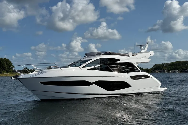  Yacht Photos Pics 2024 Sunseeker Manhattan 55 yacht cruising on a sunny day with cloudy sky.