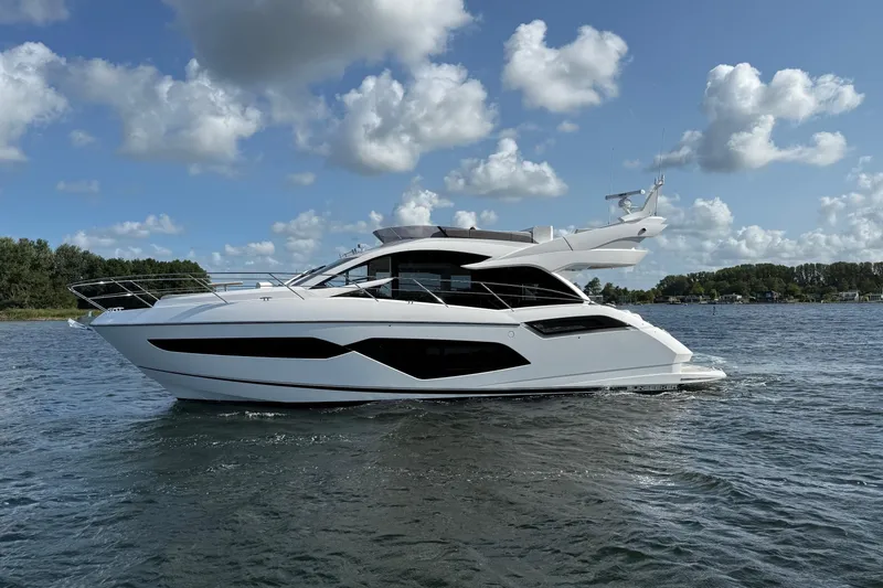  Yacht Photos Pics 2024 Sunseeker Manhattan 55 yacht cruising on a sunny day with scenic background.